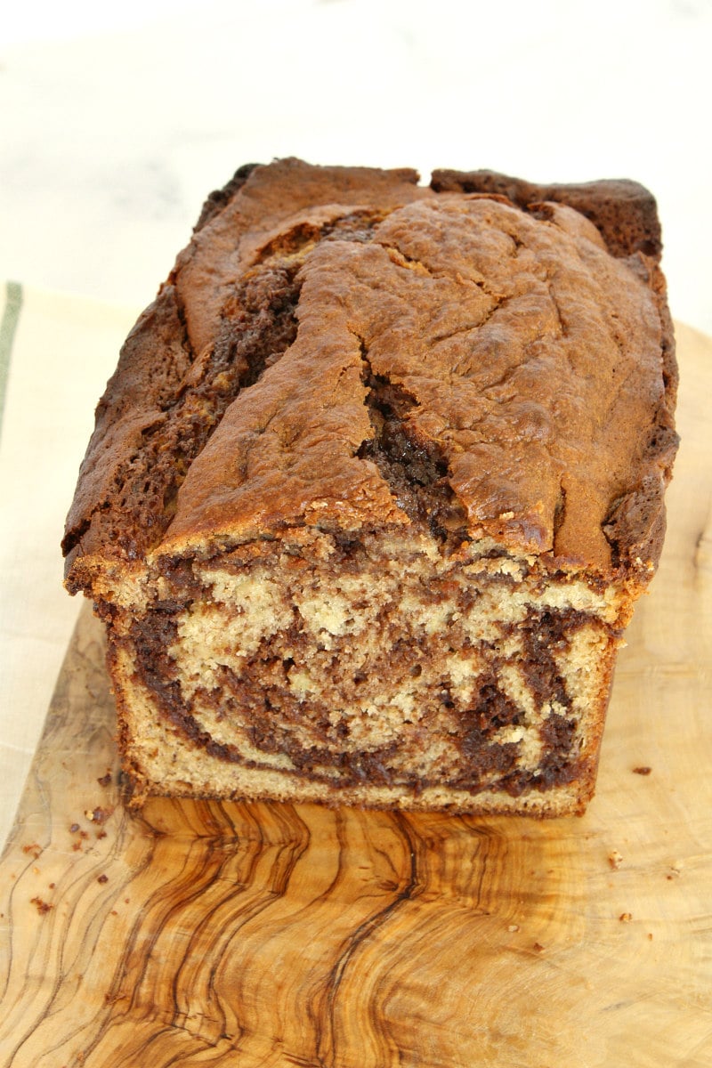 loaf of nutella banana bread on a cutting board, cut to see the inside of the bread