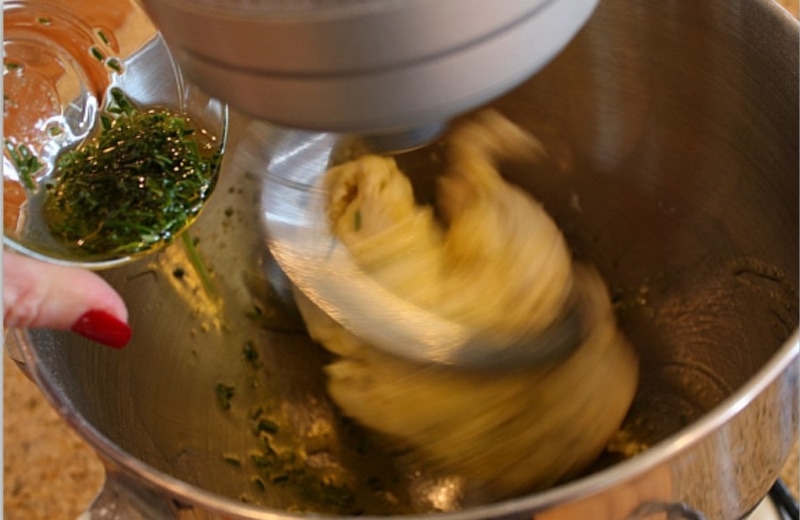 adding oil to bread dough in mixer