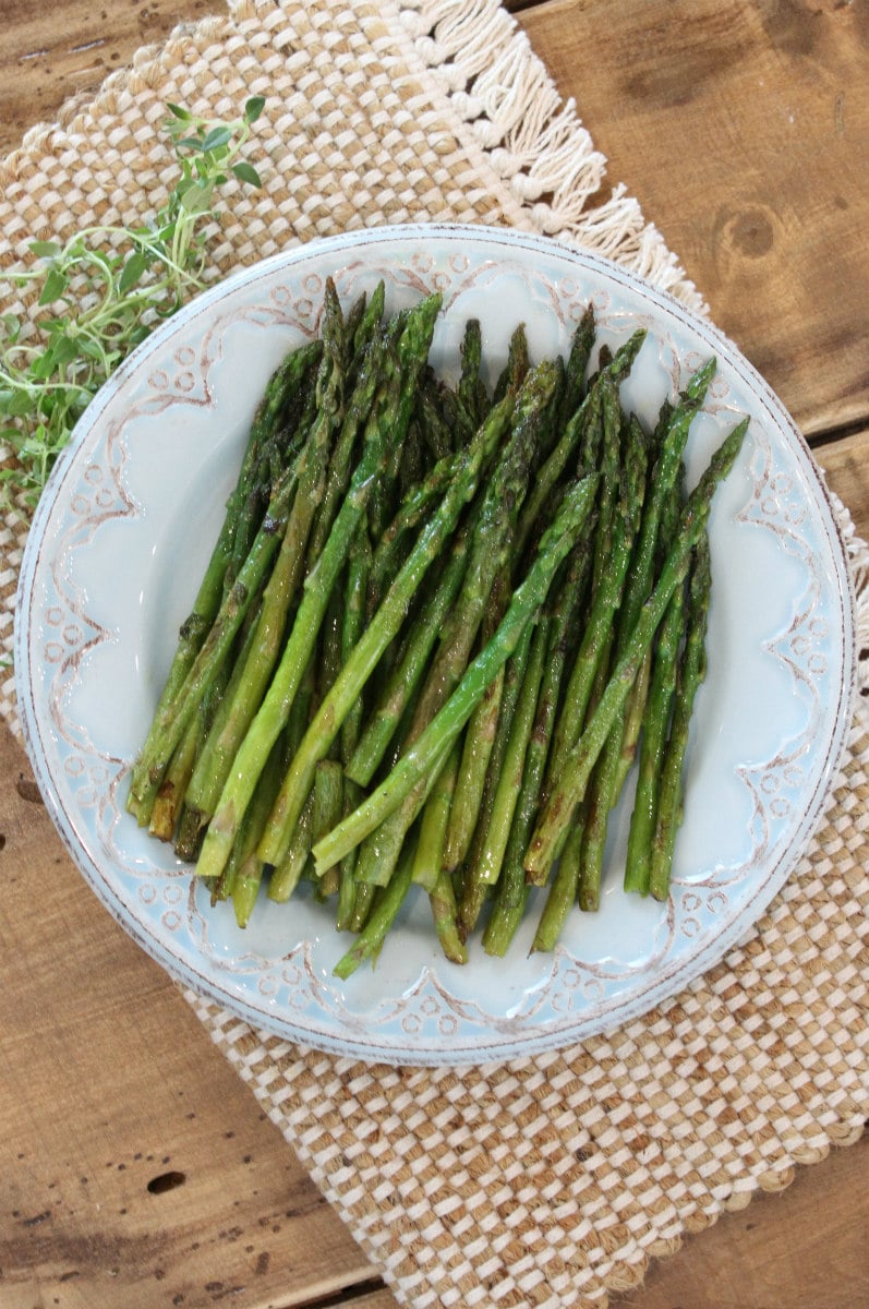 Pan Roasted Asparagus on a serving plate with fresh thyme