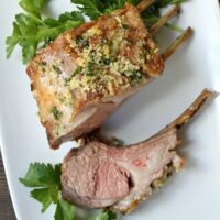 panko crusted rack of lamb cut and on plate with parsley