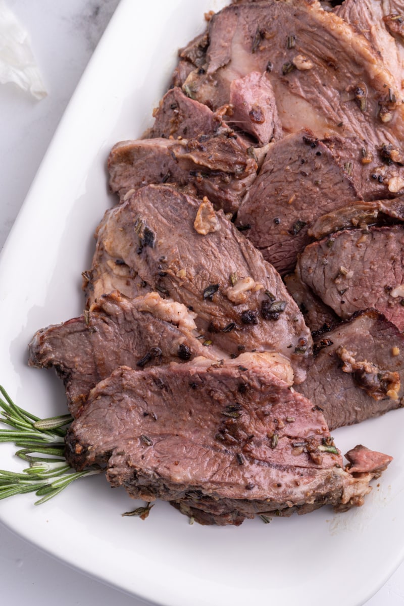 sliced leg of lamb roast on platter