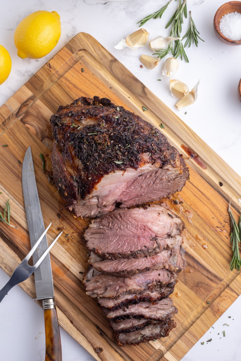 leg of lamb roast sliced on cutting board