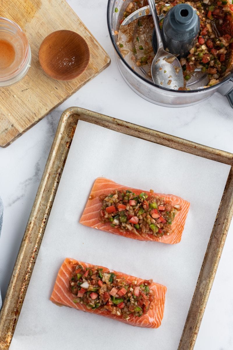 salsa topped salmon on baking sheet ready for oven