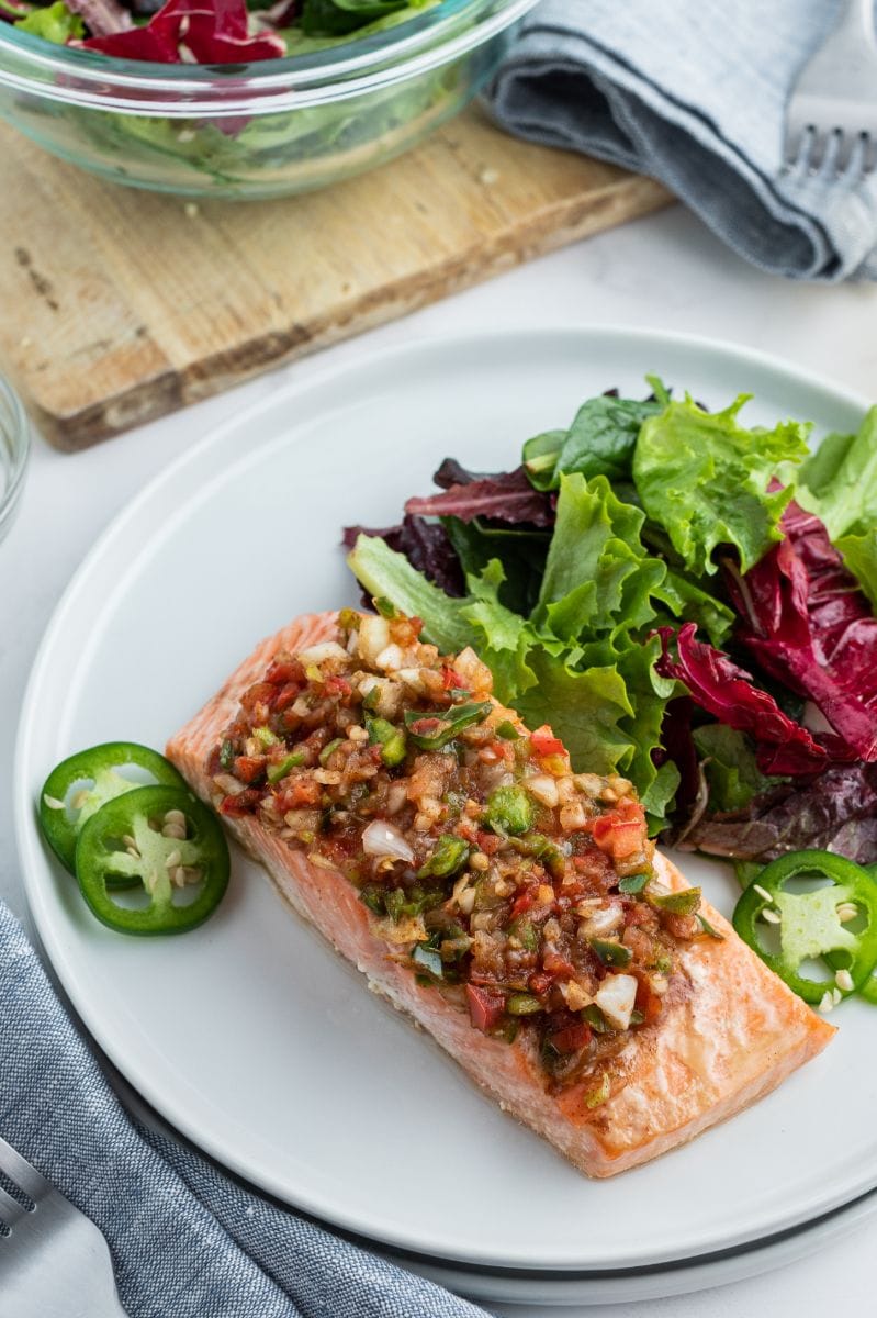 salsa roasted salmon on white plate with salad