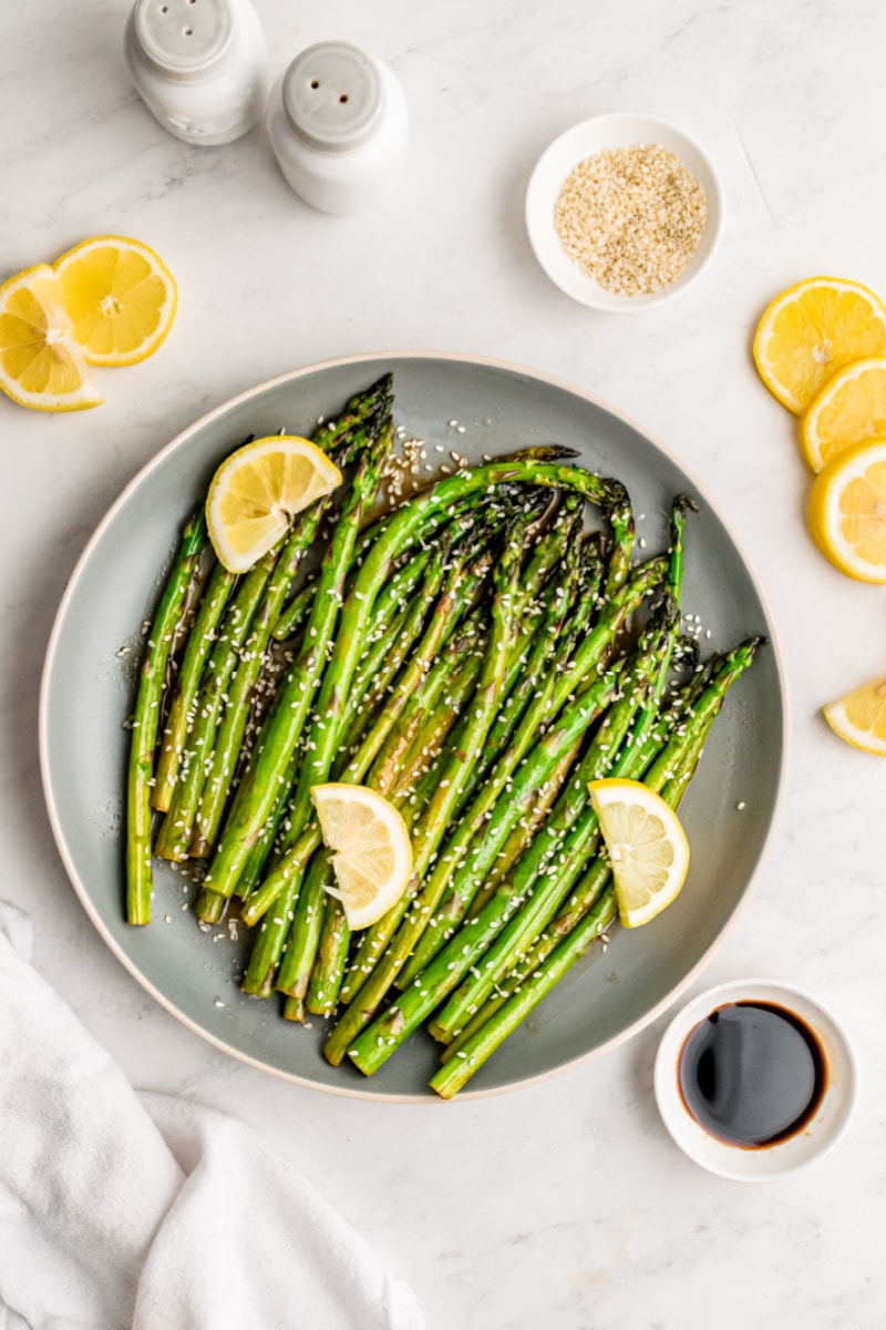 sesame asparagus with lemon wedges on plate