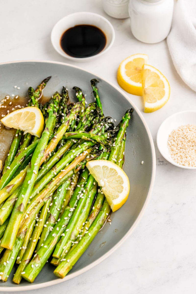 plate of asparagus with lemon wedges