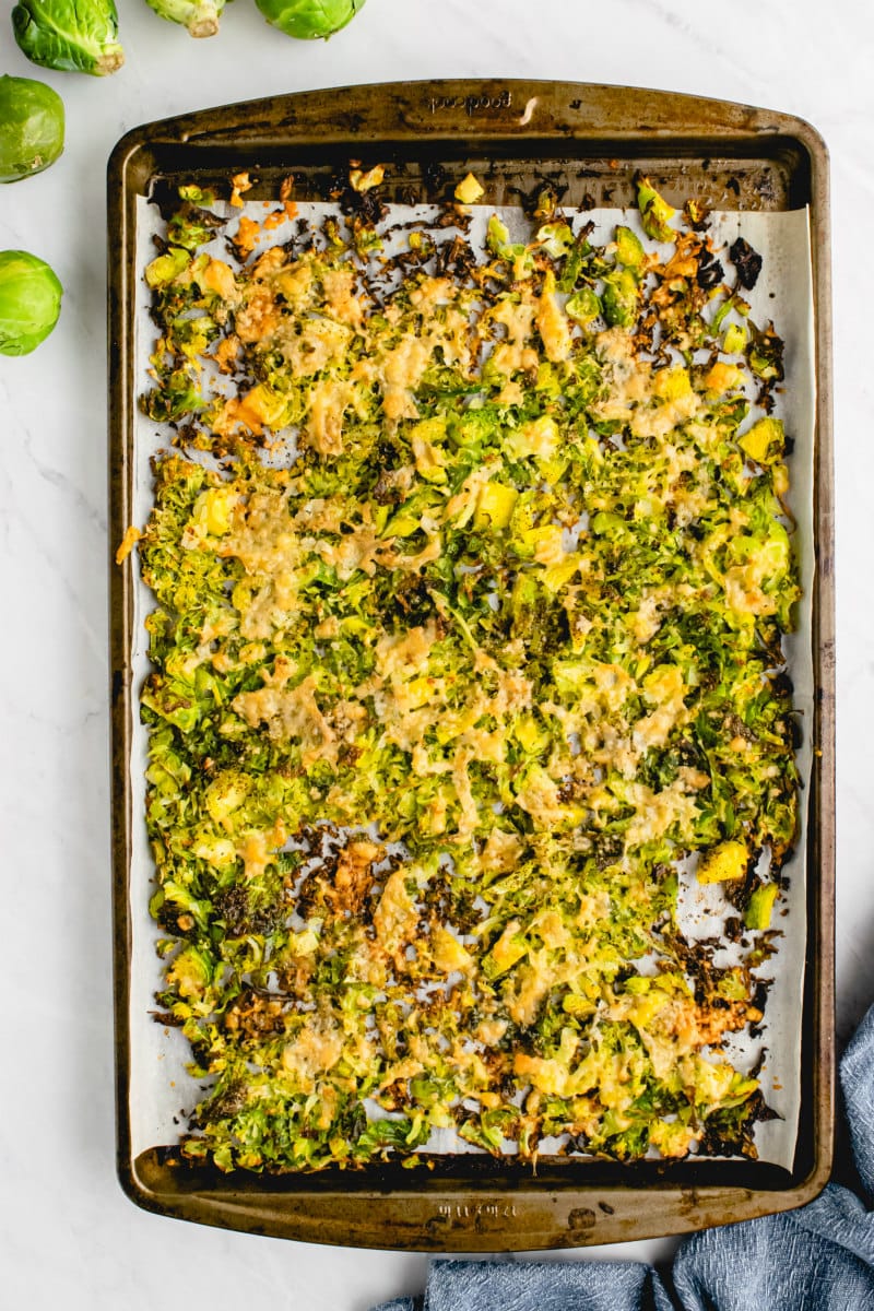 shredded parmesan brussels sprouts on baking sheet
