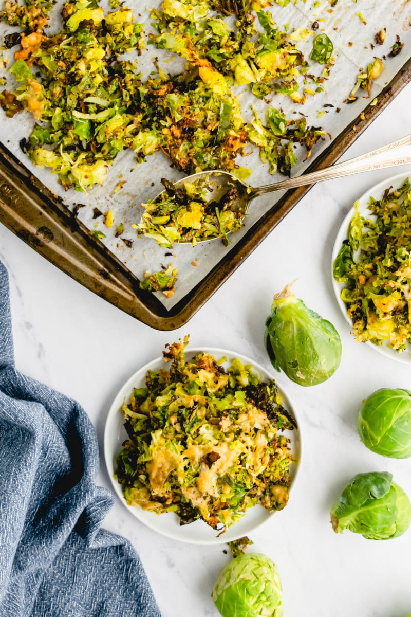 shredded parmesan brussels sprouts on baking sheet and serving plate