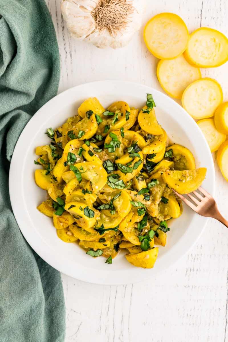 smothered yellow squash and basil in a white dish