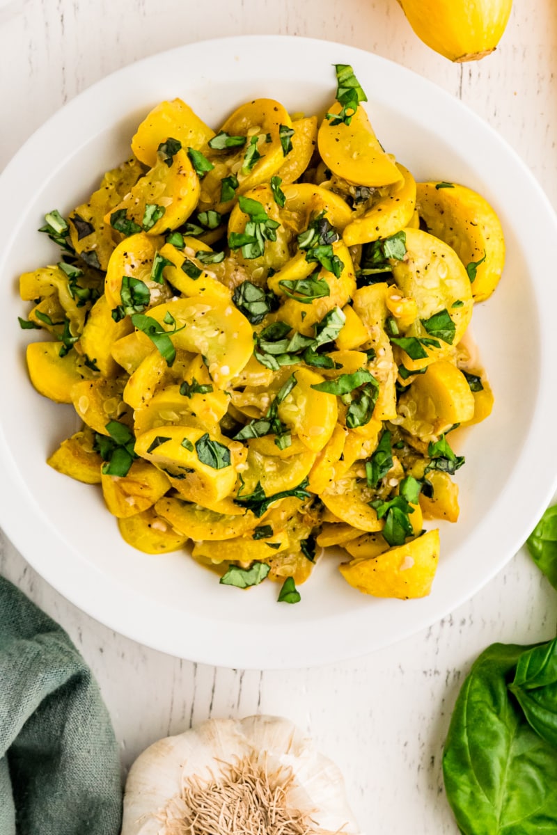 yellow squash and basil in a white bowl