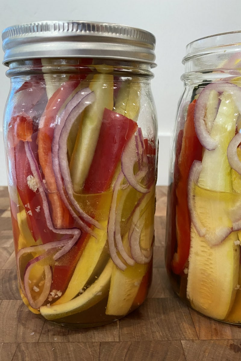 jar marinating red bell peppers, yellow squash, red onion and zucchini