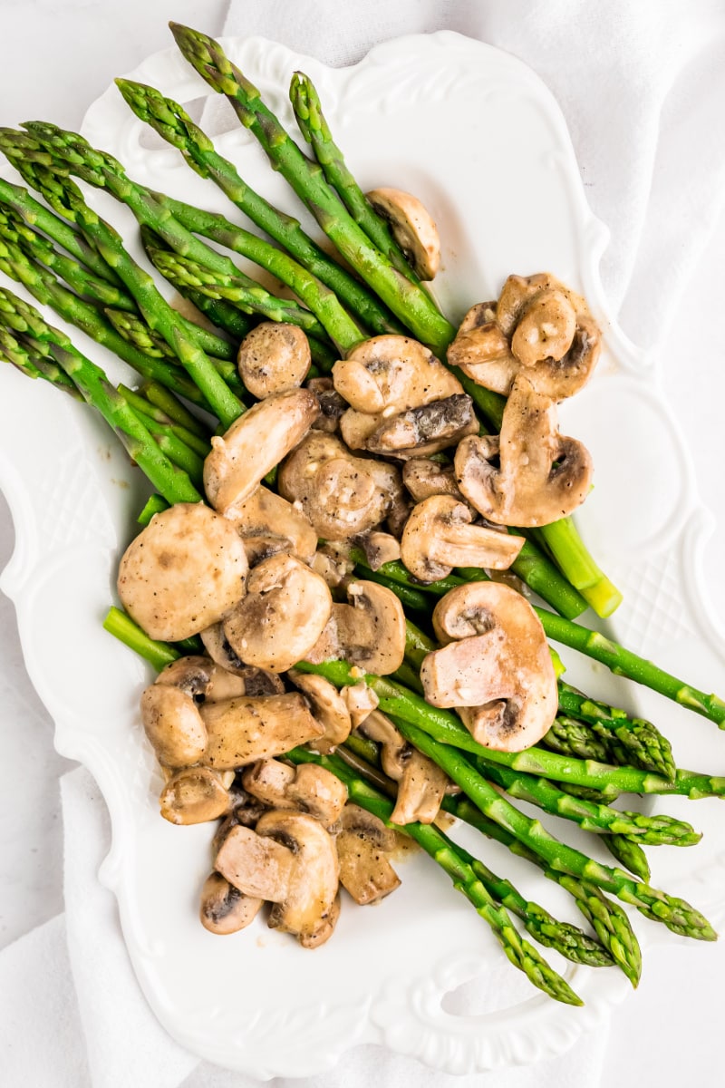 asparagus on a platter with mushroom sauce