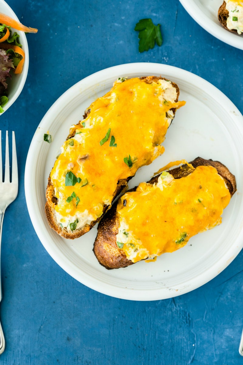 overhead shot of two tuna melts on a white plate with a fork