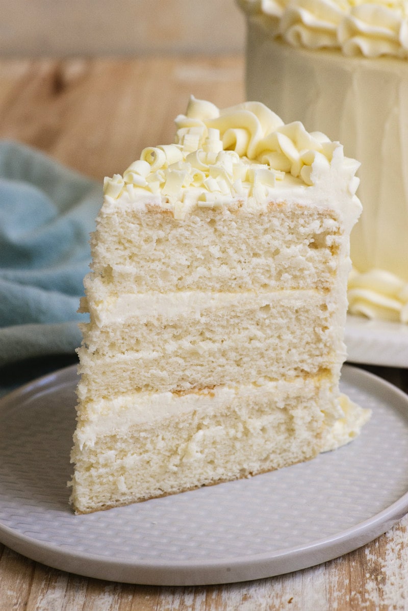 slice of three layer white wedding cake on a white plate