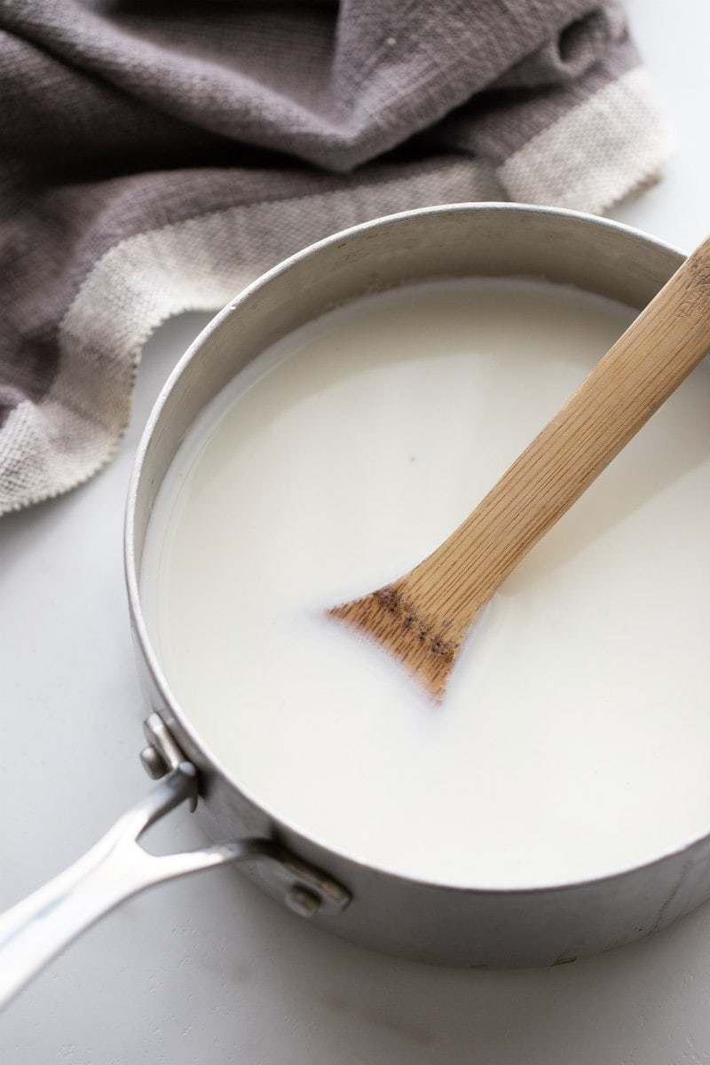 white sauce in a saucepan with wooden spoon
