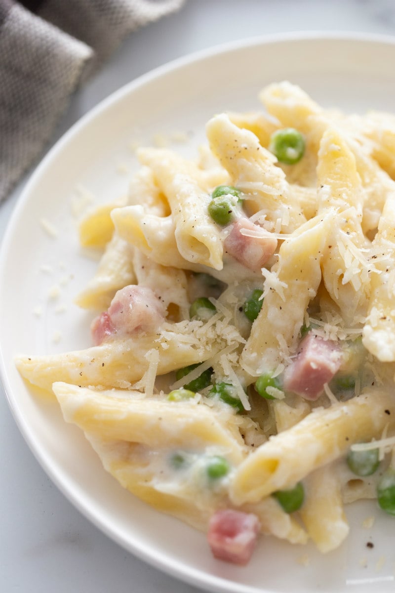 cheesy baked penne serving on white plate