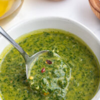 bowl of chimichurri sauce with spoon inside it