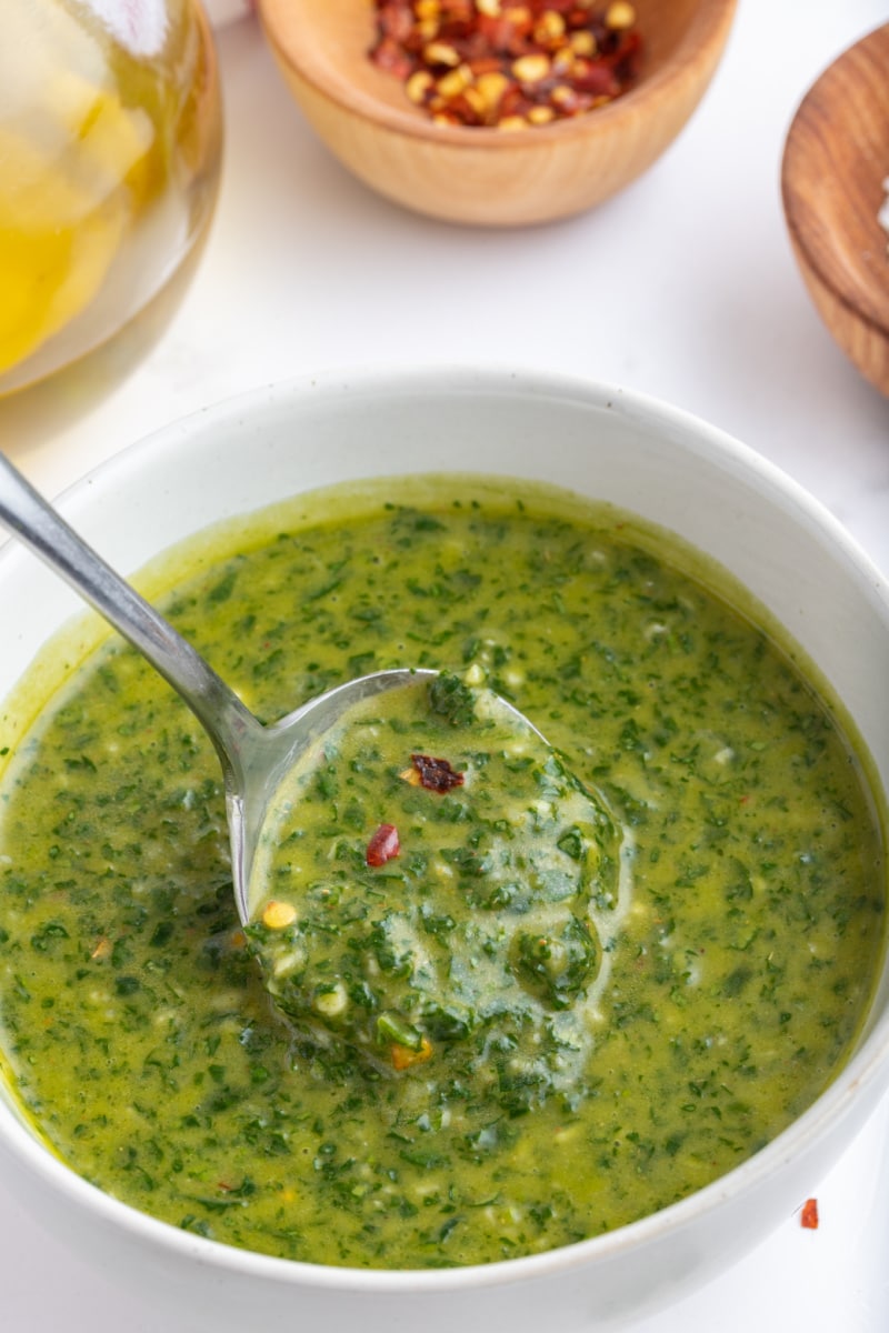 bowl of chimichurri sauce with spoon inside it