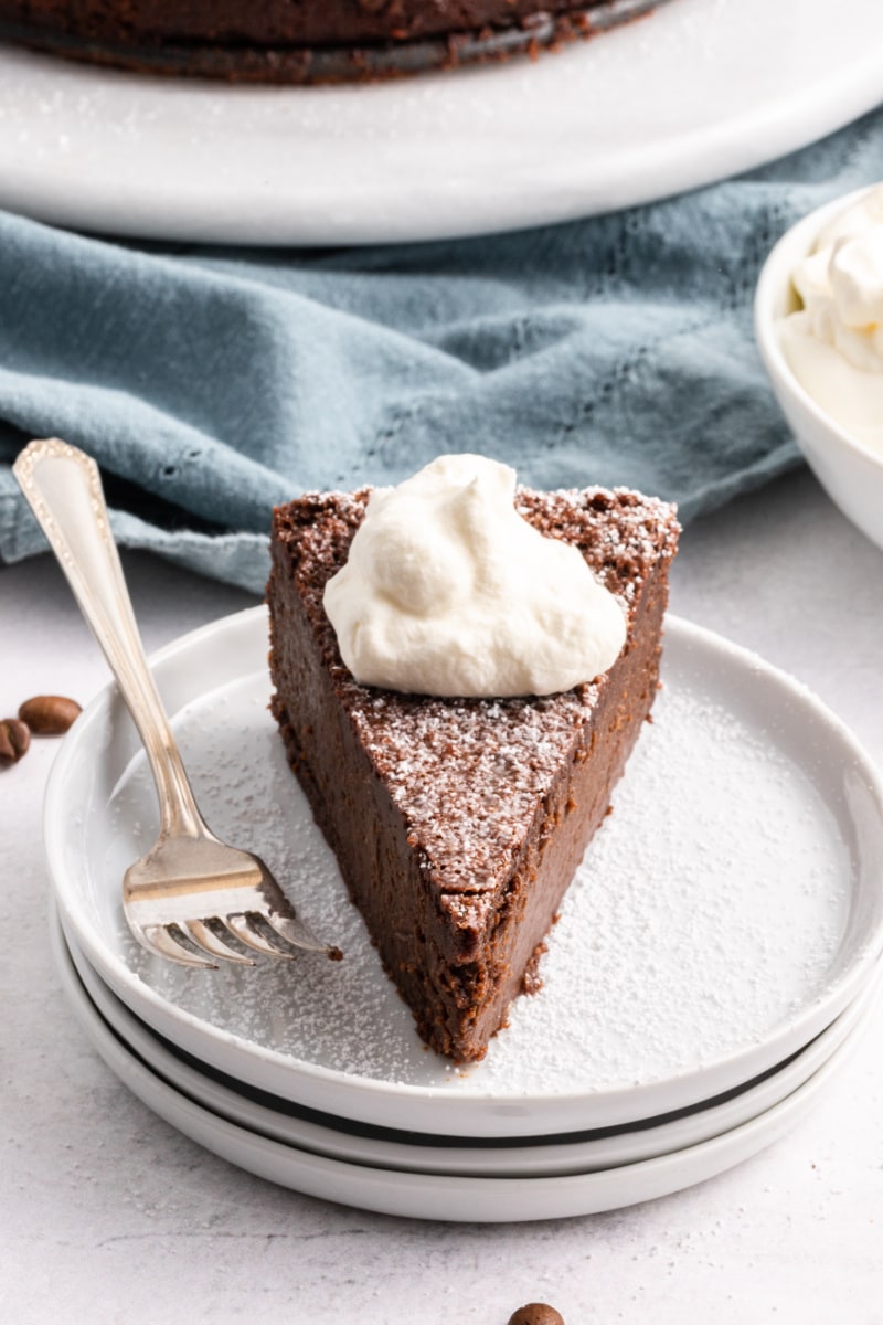 slice of chocolate espresso torte with whipped cream on plate with fork