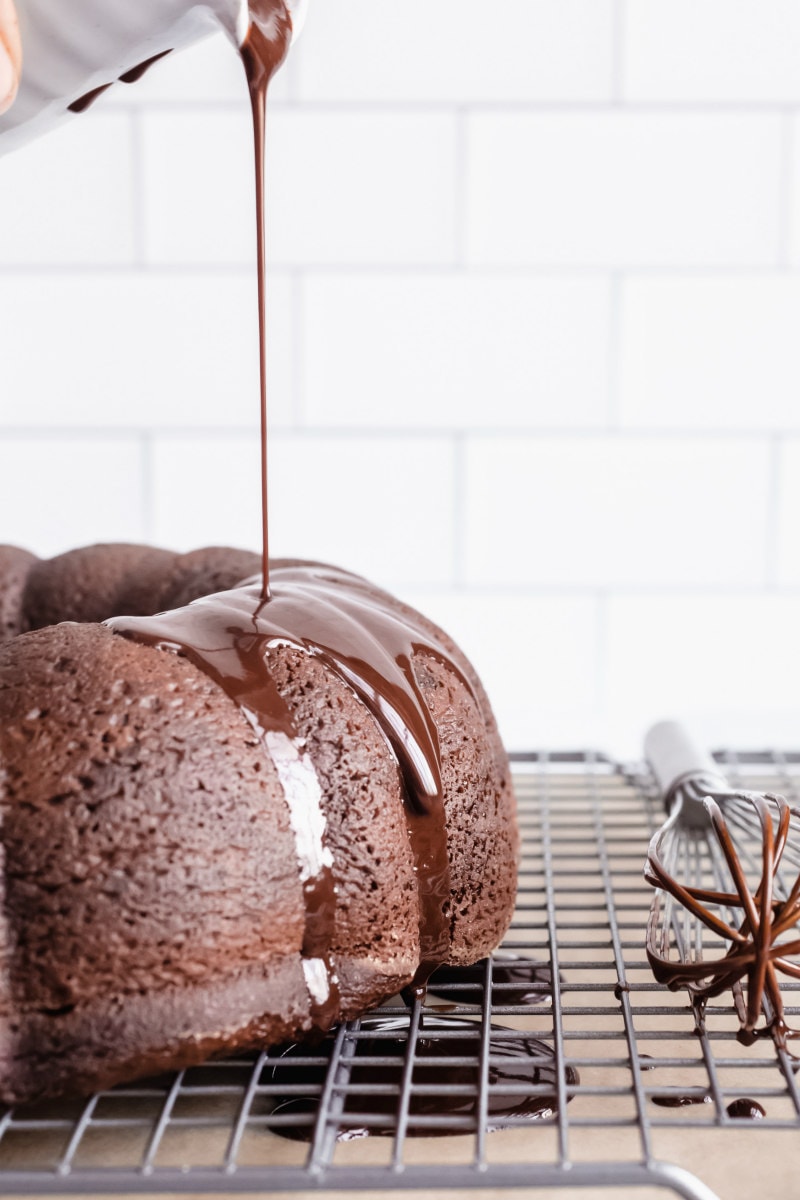 adding glaze to chocolate pudding fudge cake