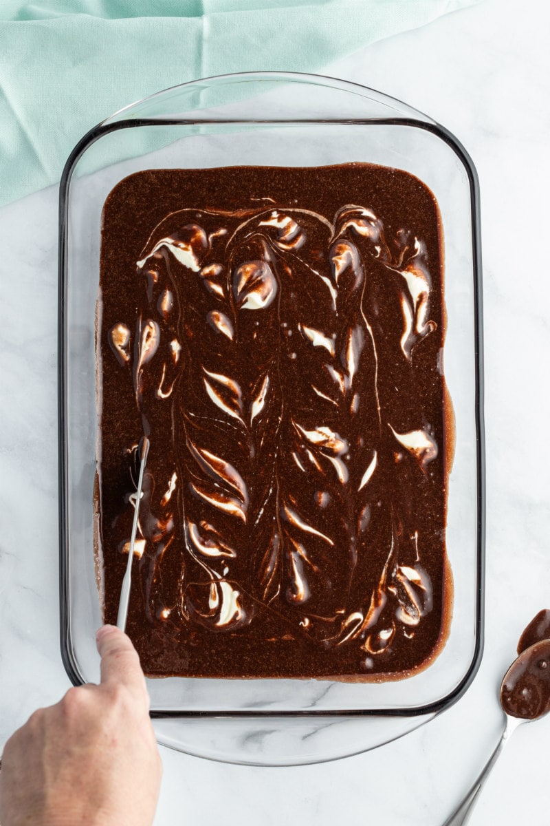 swirling cream cheese brownies in a pyrex pan