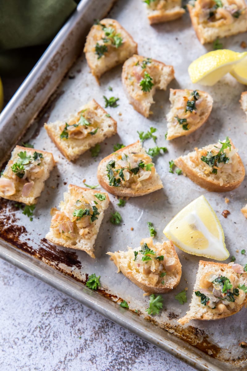 crostini with clams and lemon on a baking sheet