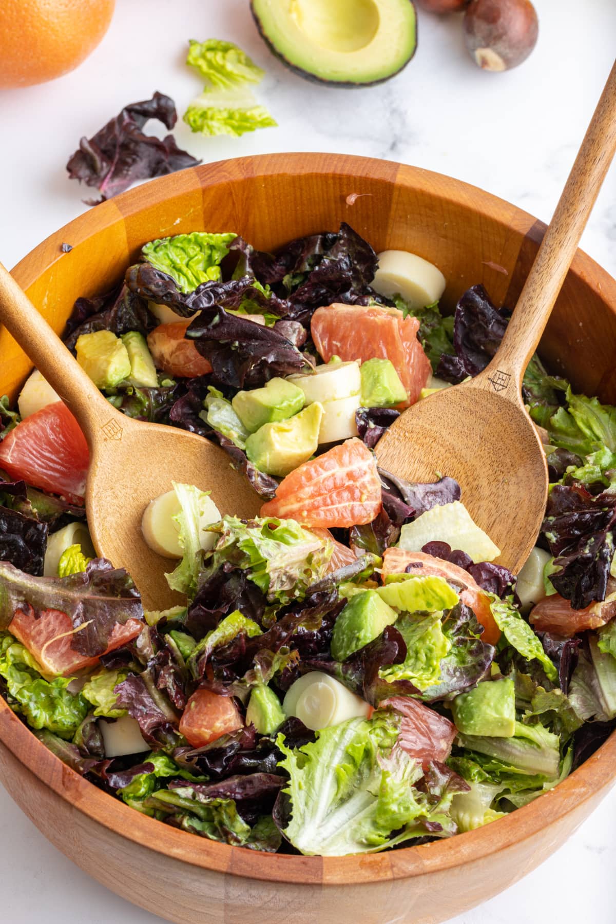 wooden bowl with servers in hearts of palm avocado salad