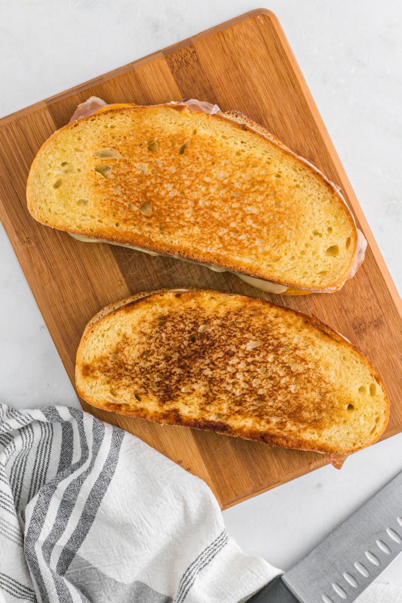 two grilled cheese sandwiches on cutting board