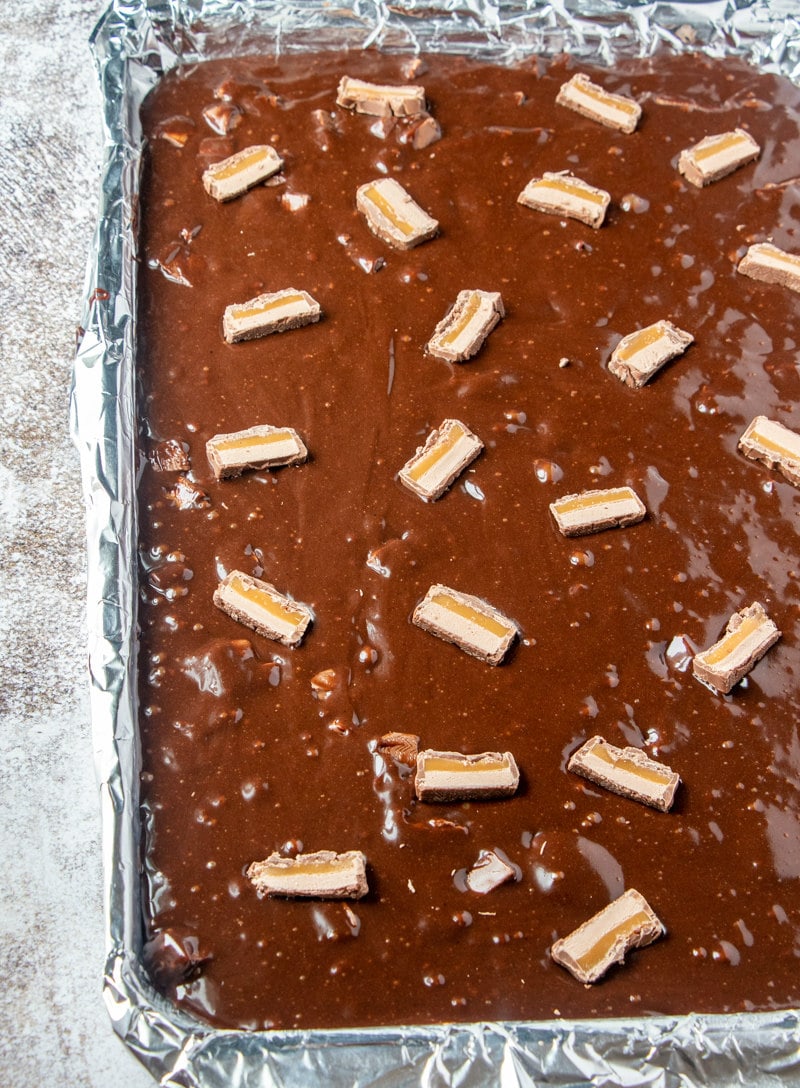 milky way brownie batter in a sheet pan ready for the oven