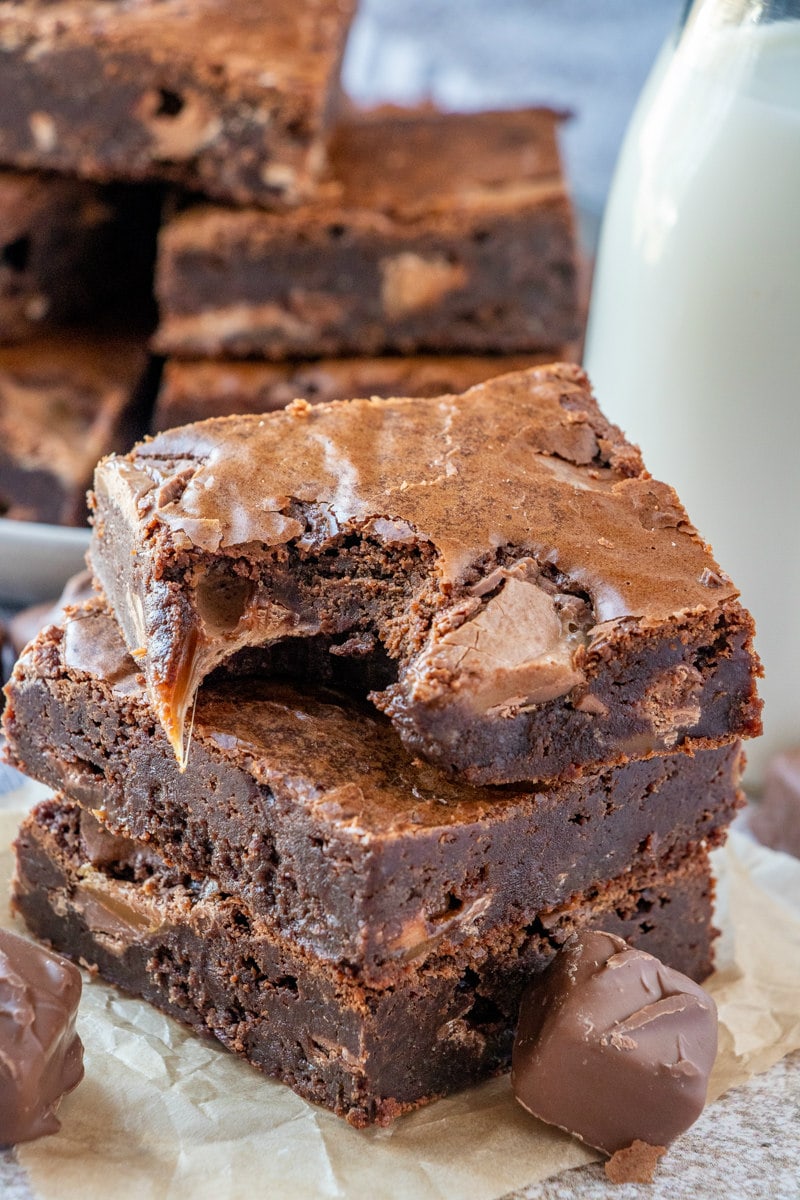 stack of three milky way brownies with a bite taken out of the one on top