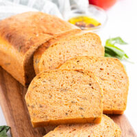 sliced tomato basil bread on a bread board