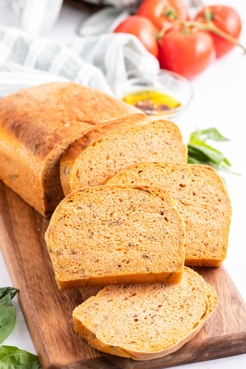 sliced tomato basil bread on a bread board