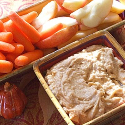apple spice hummus in a serving dish with fresh vegetables served on the side