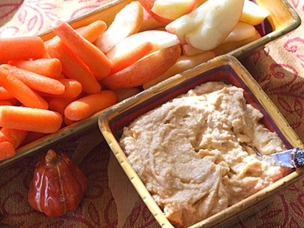 apple spice hummus in a serving dish with fresh vegetables served on the side