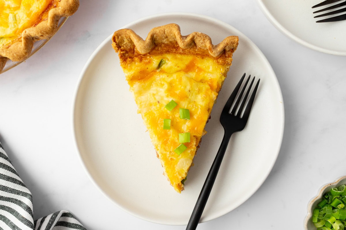 slice of bacon and cheese quiche on plate