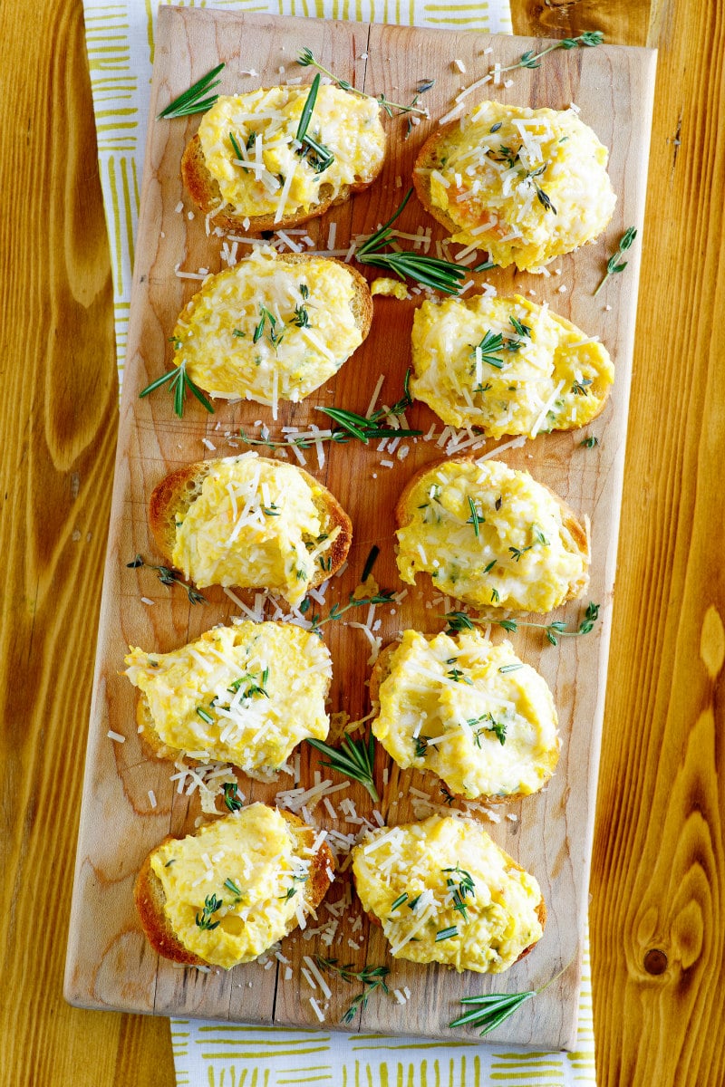 Butternut Squash Spread on baguette slices, displayed on a board for a party