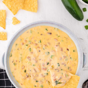 cheesy black eyed pea dip in a bowl with a chip dunked in