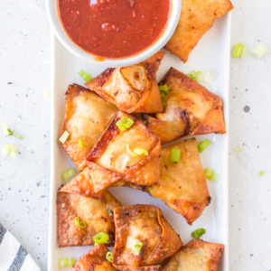 chicken and shrimp won tons on a white platter with bowl of dipping sauce