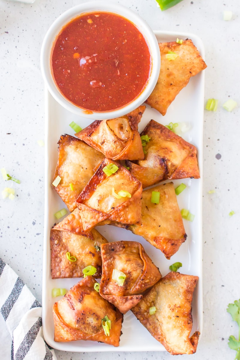 chicken and shrimp won tons on a white platter with bowl of dipping sauce