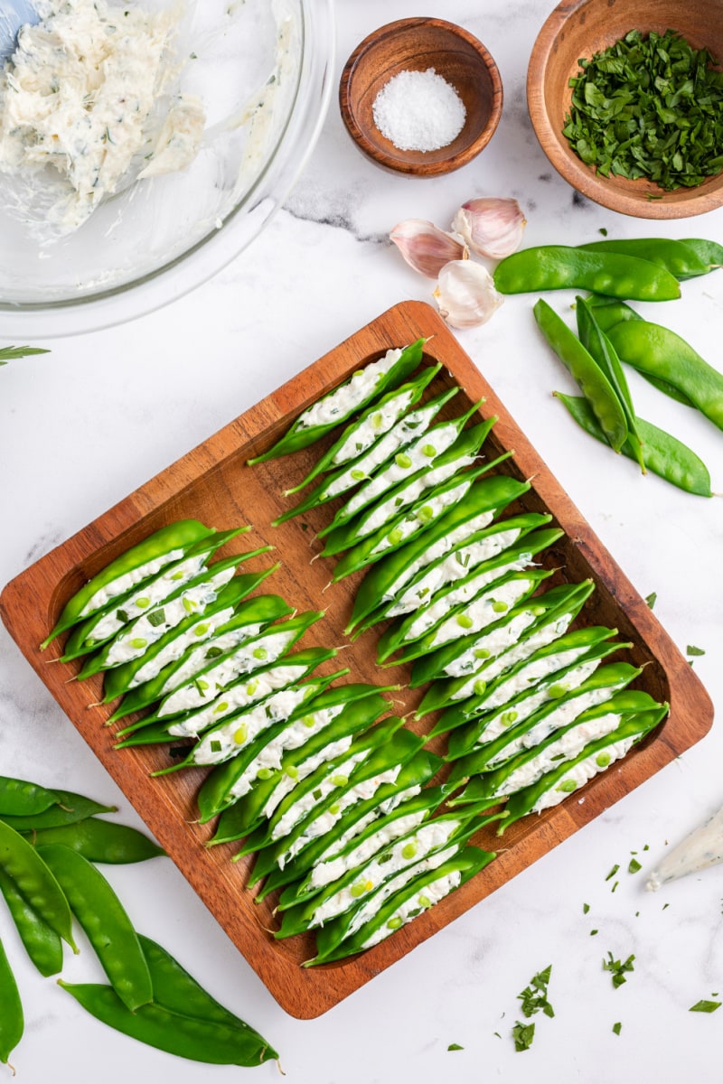 wooden tray filled with crab and cream cheese stuffed snow peas