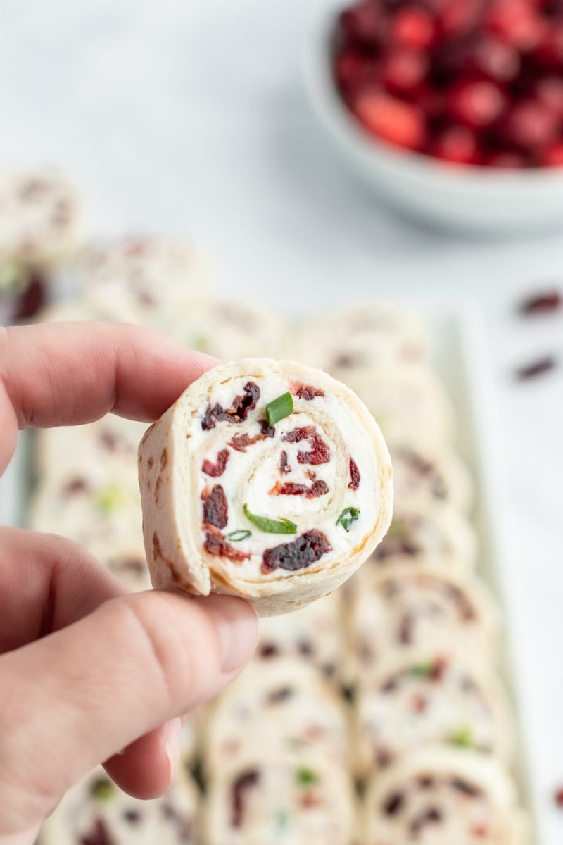 hand holding single cranberry feta pinwheel