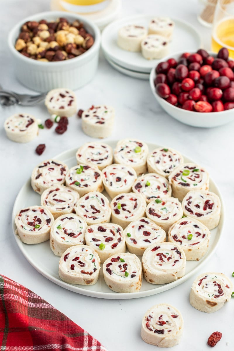 cranberry feta pinwheels on white platter displayed on appetizer table