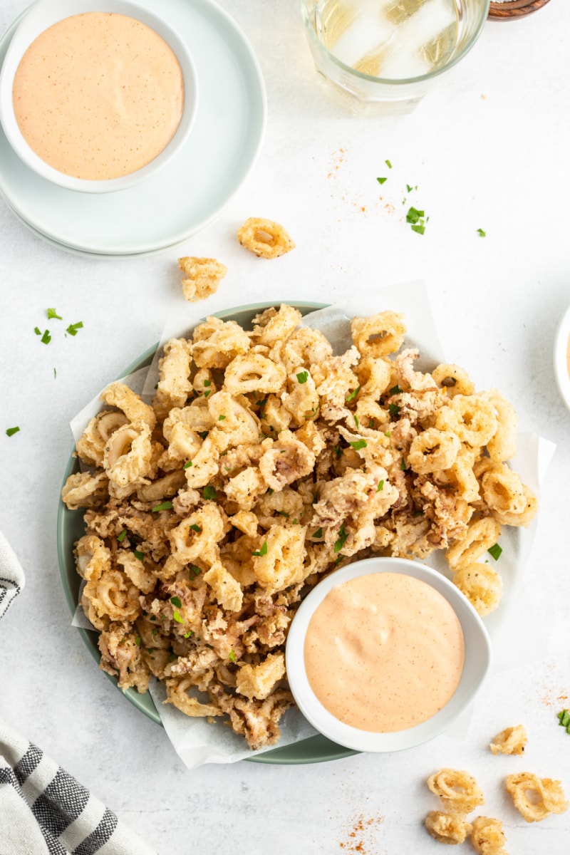 fried calamari on platter with bowl of dipping sauce