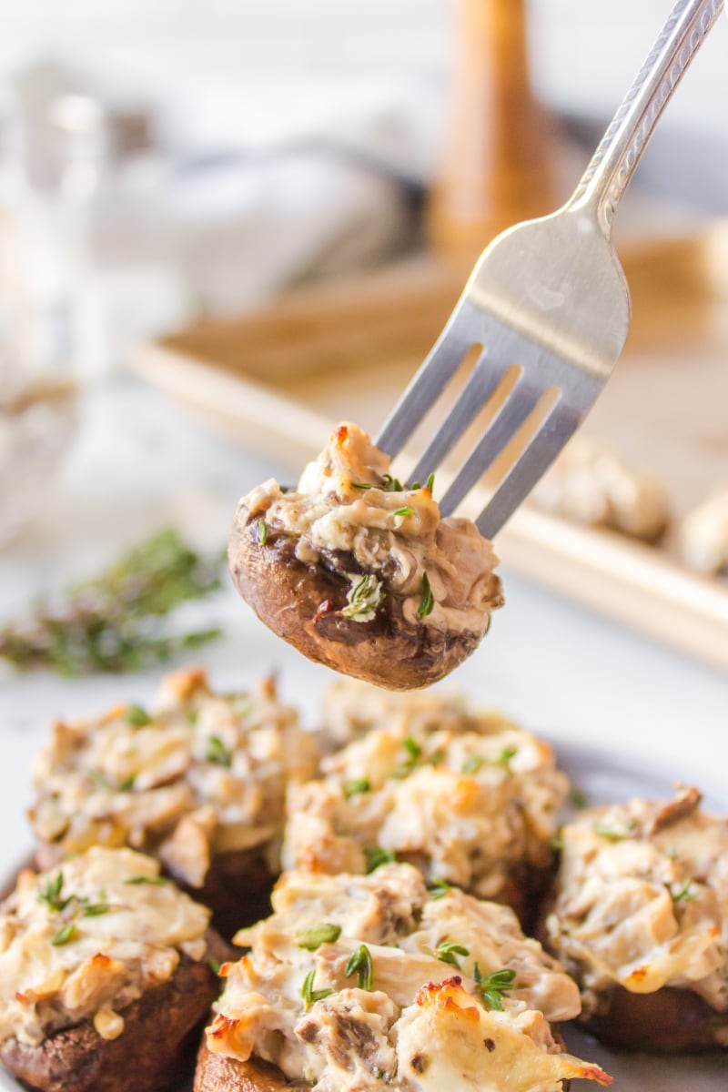 fork pulling goat cheese stuffed mushroom off platter