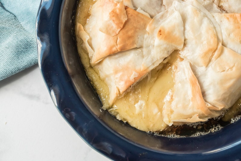 melted brie covered in phyllo in blue pie plate