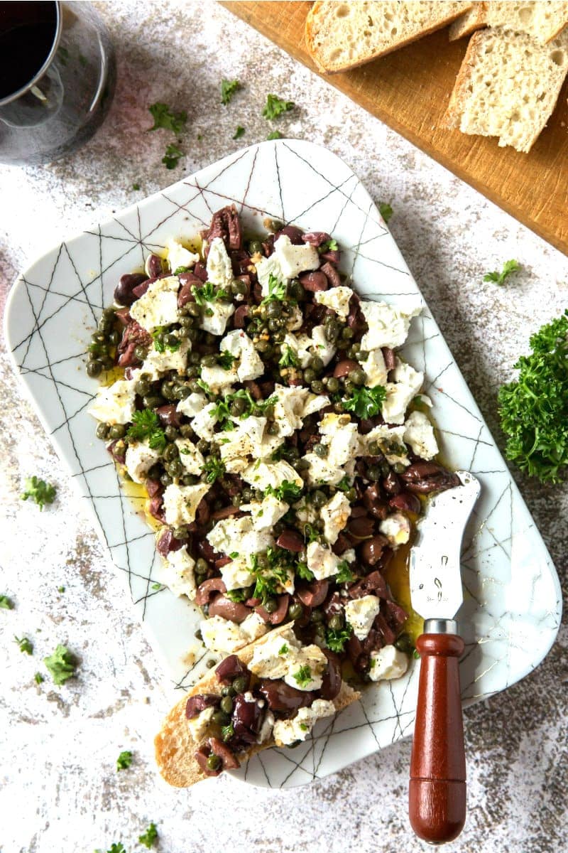 olive and goat cheese spread on a white platter