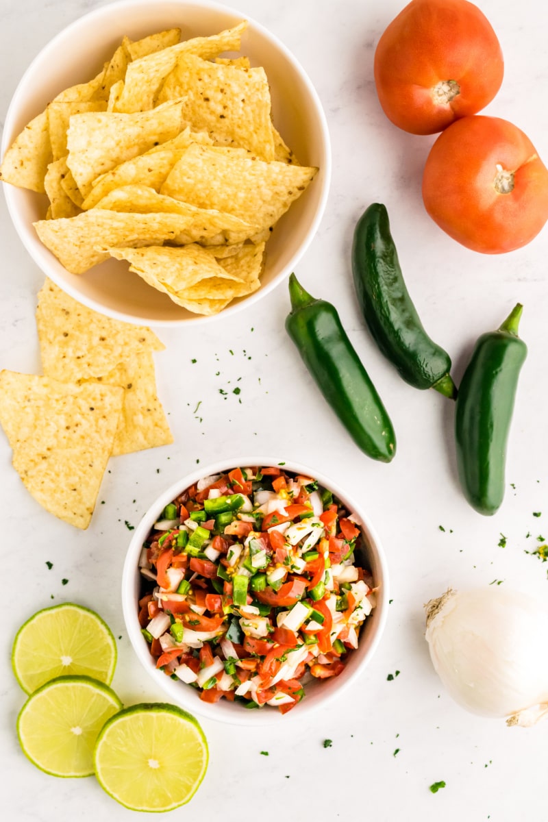 salsa in a bowl with chips and peppers