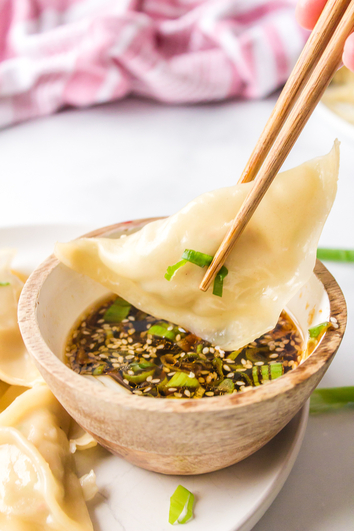Steamed Shrimp Dumplings recipe from RecipeGirl.com : Asian dumplings with sesame dipping sauce : Weight Watchers chopsticks dipping dumpling into sauce