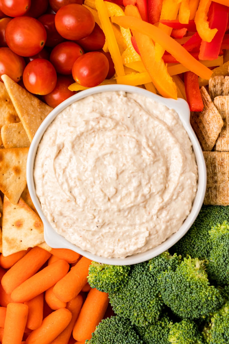 bowl of sweet caramelized onion spread surrounded by veggies and crackers