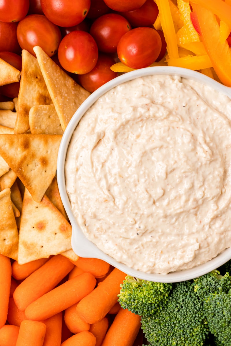 bowl of sweet caramelized onion spread with veggies and crackers